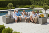 Family sitting on a patio with outdoor furniture by a pool