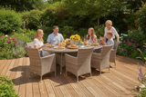 Family enjoying a meal outdoors on a wooden deck with garden surroundings.