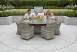 Family of four sitting around a round outdoor dining table with chairs in a garden setting.