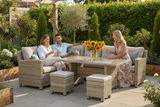 People sitting on a patio set with a table and chairs in a garden setting.