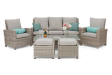 A 5-piece outdoor wicker patio conversation set featuring a 3-seat sofa, two armchairs, a glass-top coffee table, and two ottomans, all in a light gray and beige wicker weave with light gray cushions and teal accent pillows.
