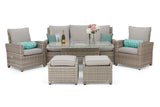 Outdoor patio furniture set with cushions and a bottle of wine on a stone patio.