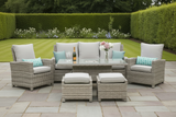 Outdoor patio furniture set with cushions and a bottle of wine on a stone patio.