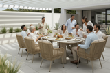Group of people dining outdoors on a patio with modern architecture.