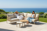 Two women sitting on a patio set with ocean view