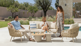 People sitting on outdoor furniture by a pool with a scenic background