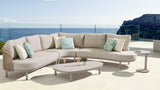 Outdoor patio set with a sectional sofa and coffee table on a sunny day.