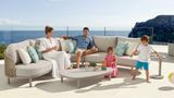 Outdoor patio set with a sectional sofa and coffee table on a sunny day.
