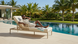 Man relaxing on a lounge chair by a pool with palm trees in the background