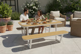 Outdoor patio set with wooden table and benches on a tiled patio.