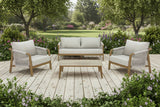 Outdoor furniture set on a wooden deck with a garden background