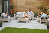 Family sitting on outdoor furniture set in a garden