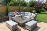 People sitting on a patio set with a table and chairs in a garden.